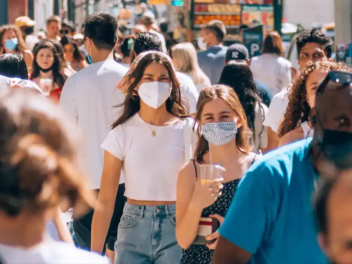 Woman wearing mask in a crowd.