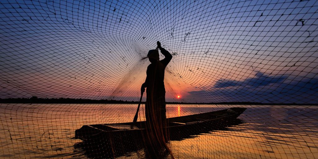 Benefits from the Sea - Man fishing with a net.