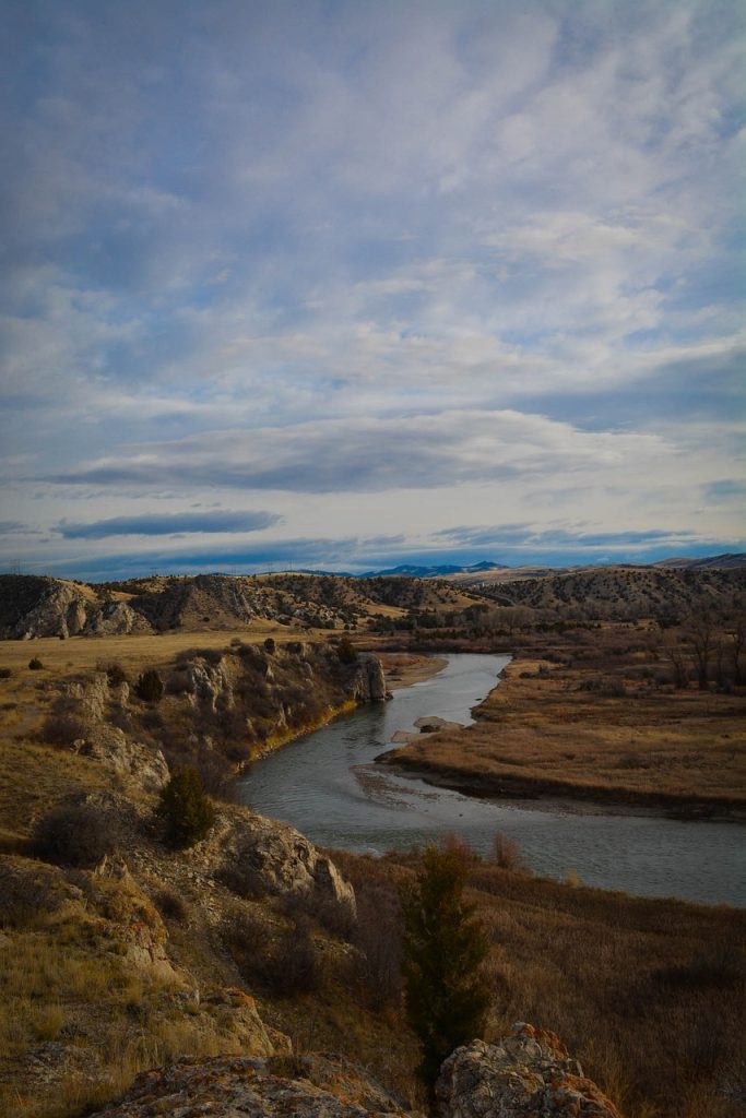 View of river against brown riverbanks and blue sky