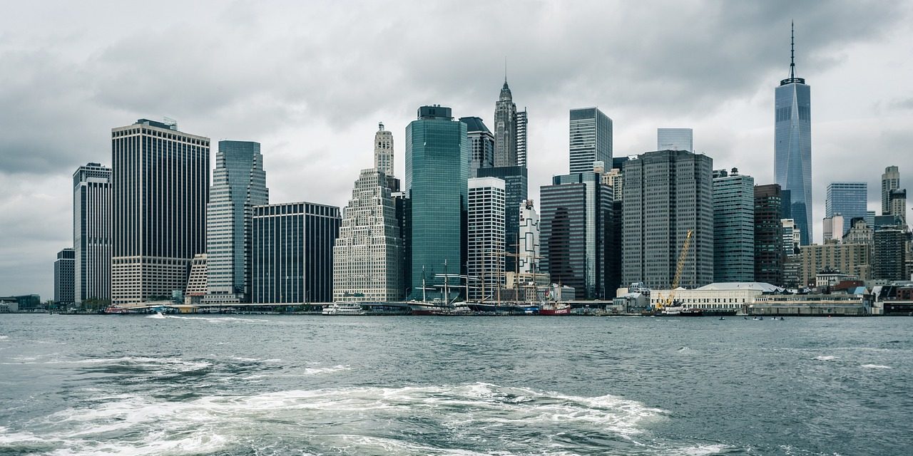 Tall city buildings with water in the foreground