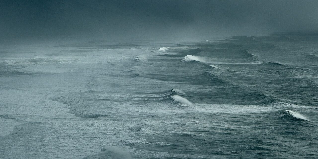 Ocean surface against a dark misty sky