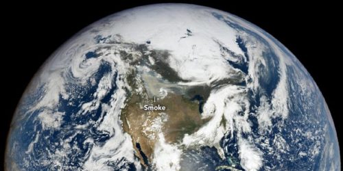 Earth from space showing the North American continent with a gray patch over Canada labelled 'smoke'