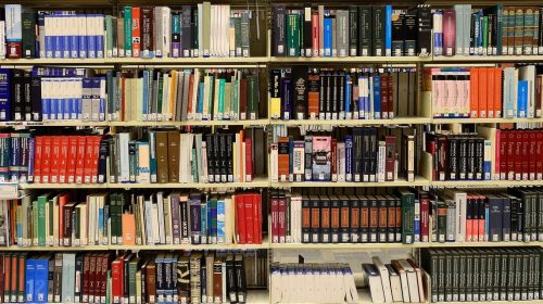 Library bookshelf with five shelves, filled with books