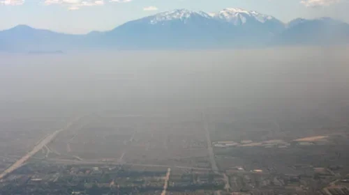 Smog over a city with mountains in the background