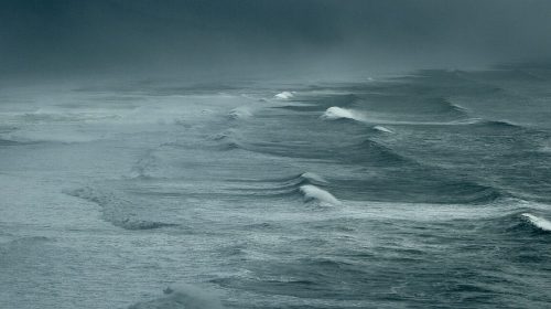 Ocean surface against a dark misty sky