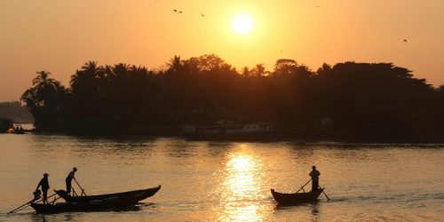 A sunset over water with boaters
Credit: Pixabay